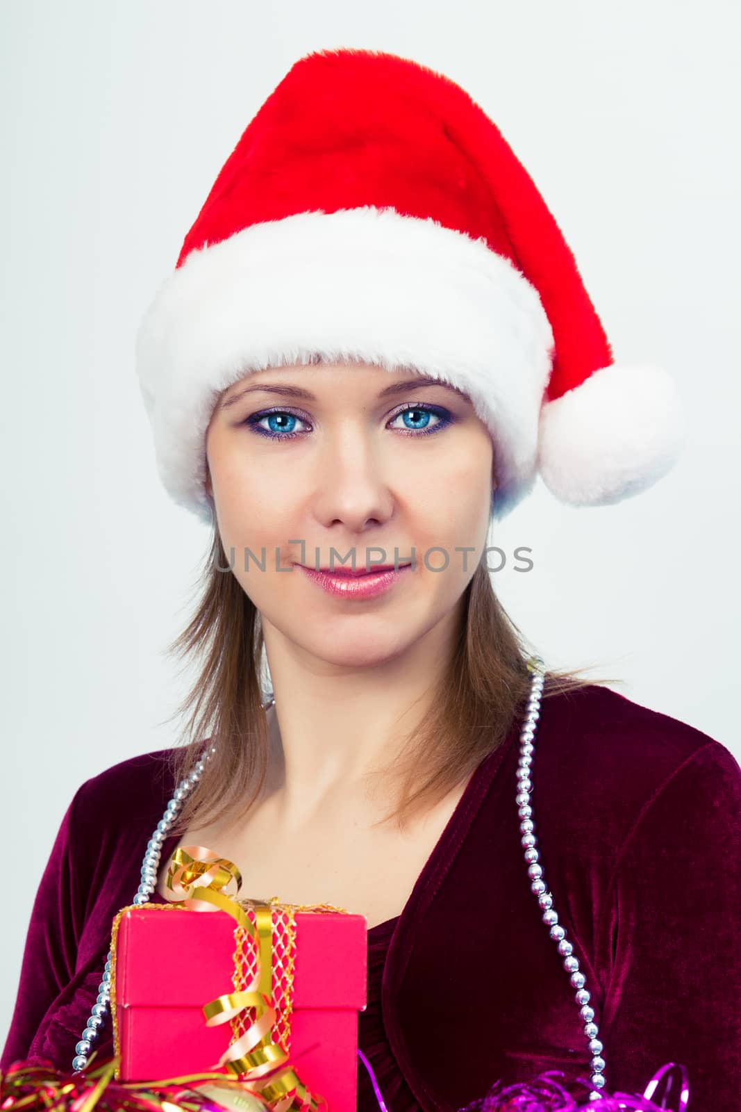 Attractive happy girl in santa hat with gift boxes