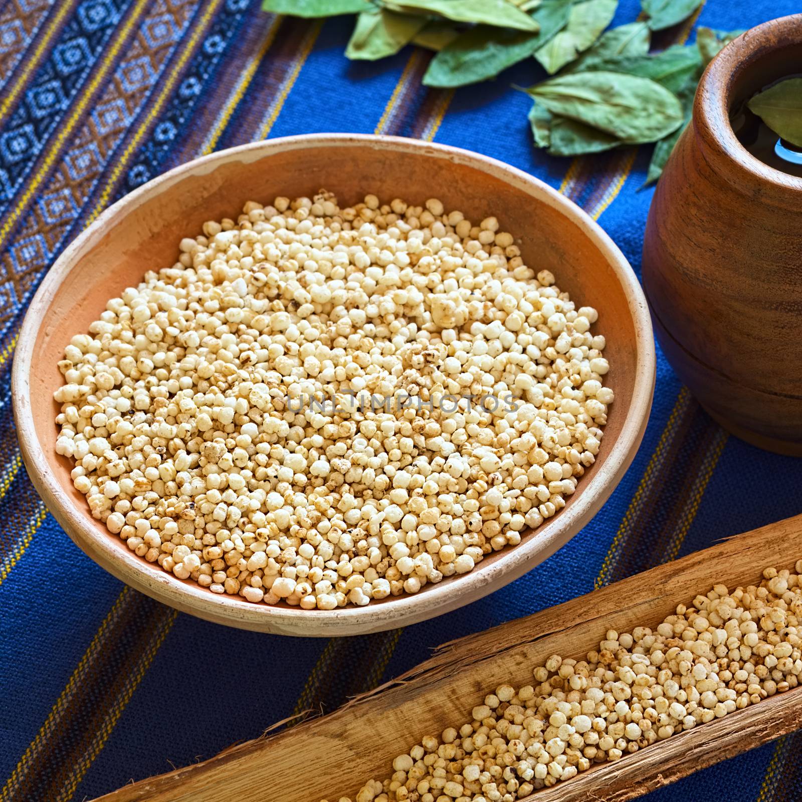 Bolivian popped quinoa cereal in small clay bowl with coca tea on the side, photographed with natural light (Selective Focus, Focus on the front of the popped quinoa in the bowl)