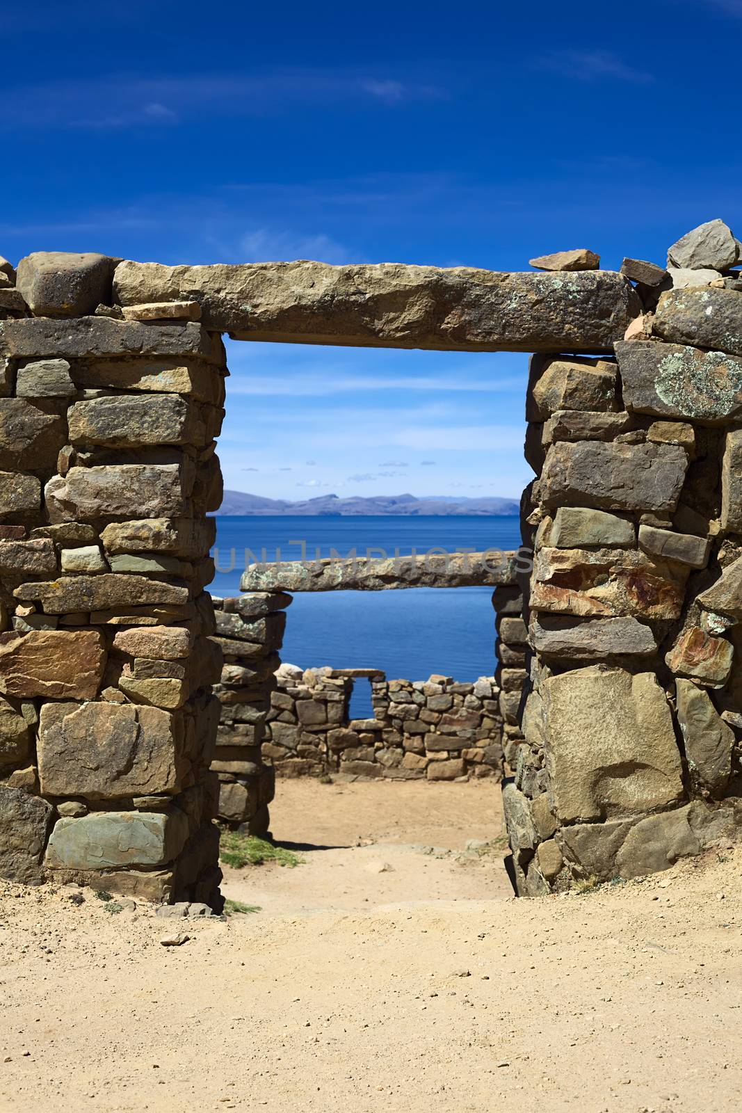 View through a door frame of the Chinkana archeological site of Tiwanaku (Tiahuanaco) origin on the Northwestern part of the Isla del Sol (Island of the Sun) in Lake Titicaca in Bolivia. Isla del Sol is a popular tourist destination and is reachable by boat from Copacabana, Bolivia. (Selective Focus, Focus on the first door frame)