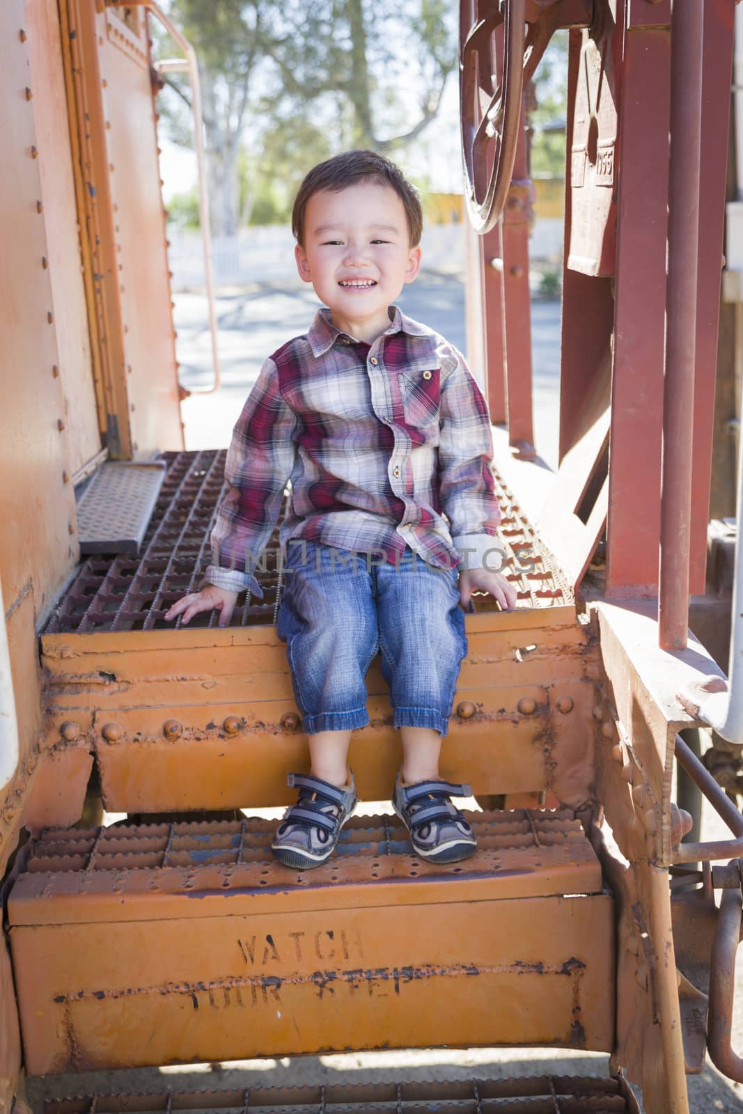 Cute Young Mixed Race Boy Having Fun Outside Sitting on Railroad Car Steps.