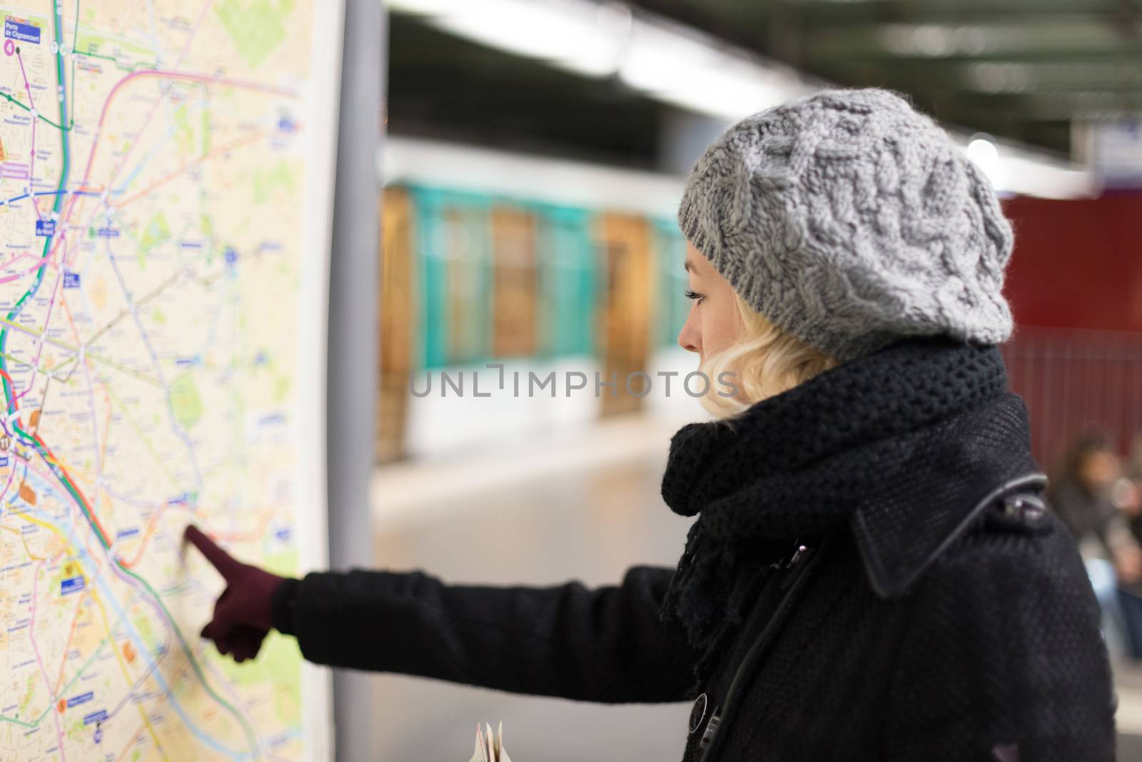 Lady looking on public transport map panel. by kasto