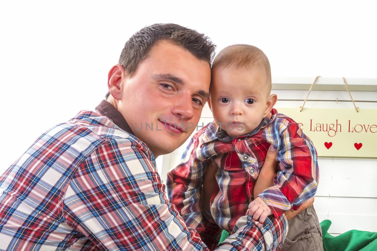 Baby boy with his father on white background