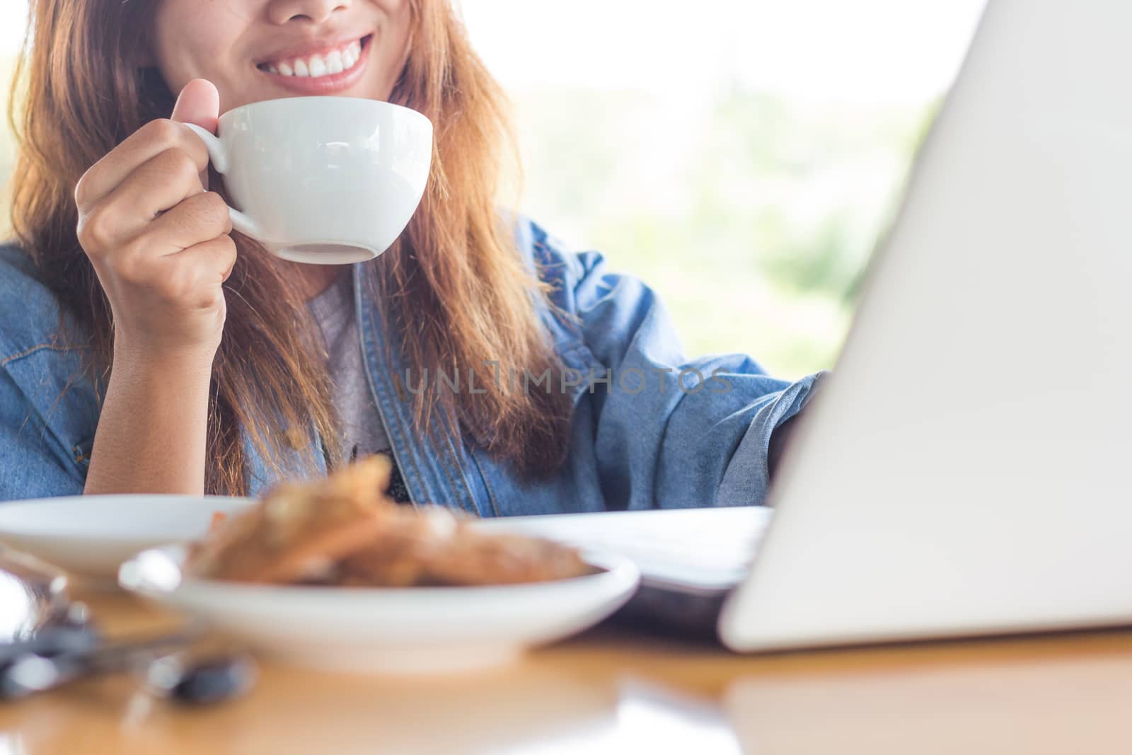 women smile drink coffee and use laptop computer