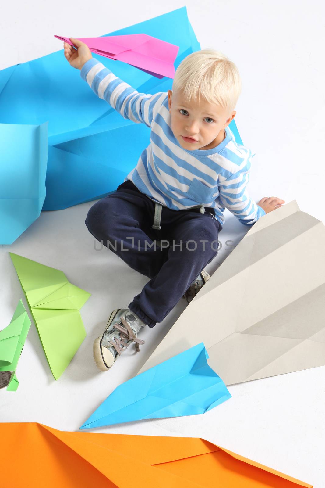 A little boy holds in his hand a paper airplane