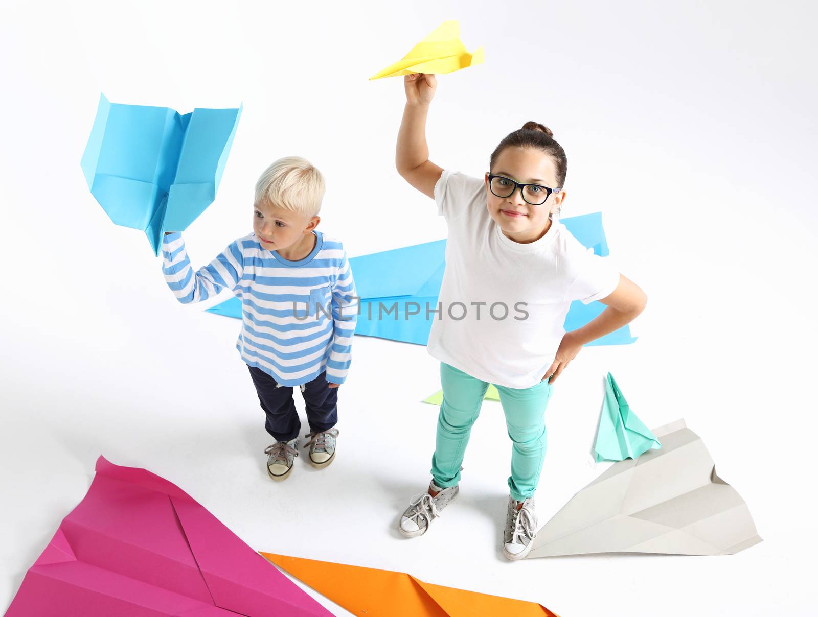 Siblings, a girl and a boy throwing paper airplane