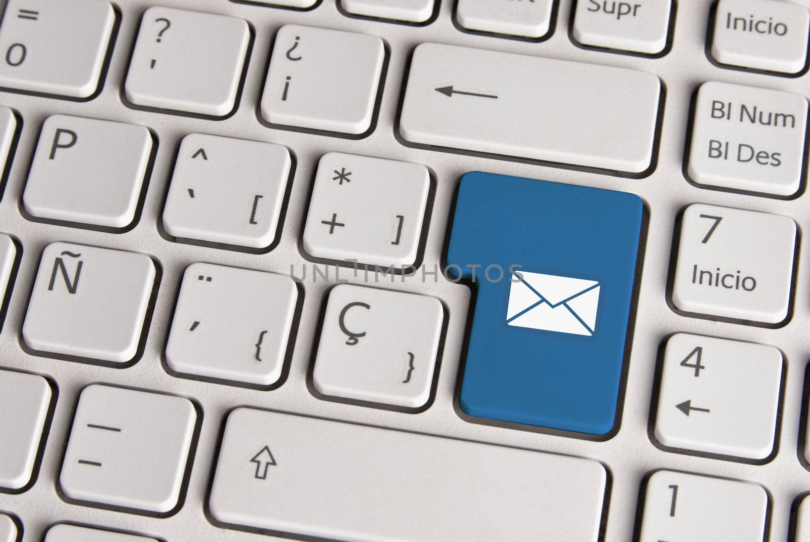 Spanish keyboard with email concept mail envelope icon over blue background button. Image with clipping path for easy change the key color and editing.
