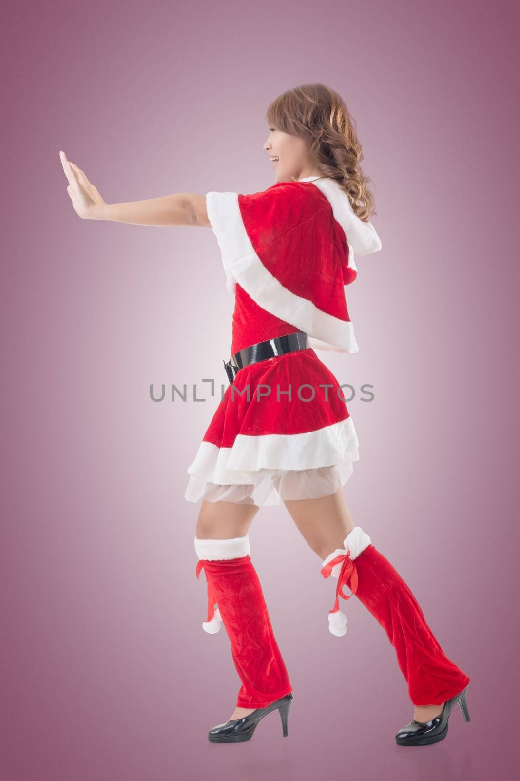 Christmas girl push something, full length pose isolated.