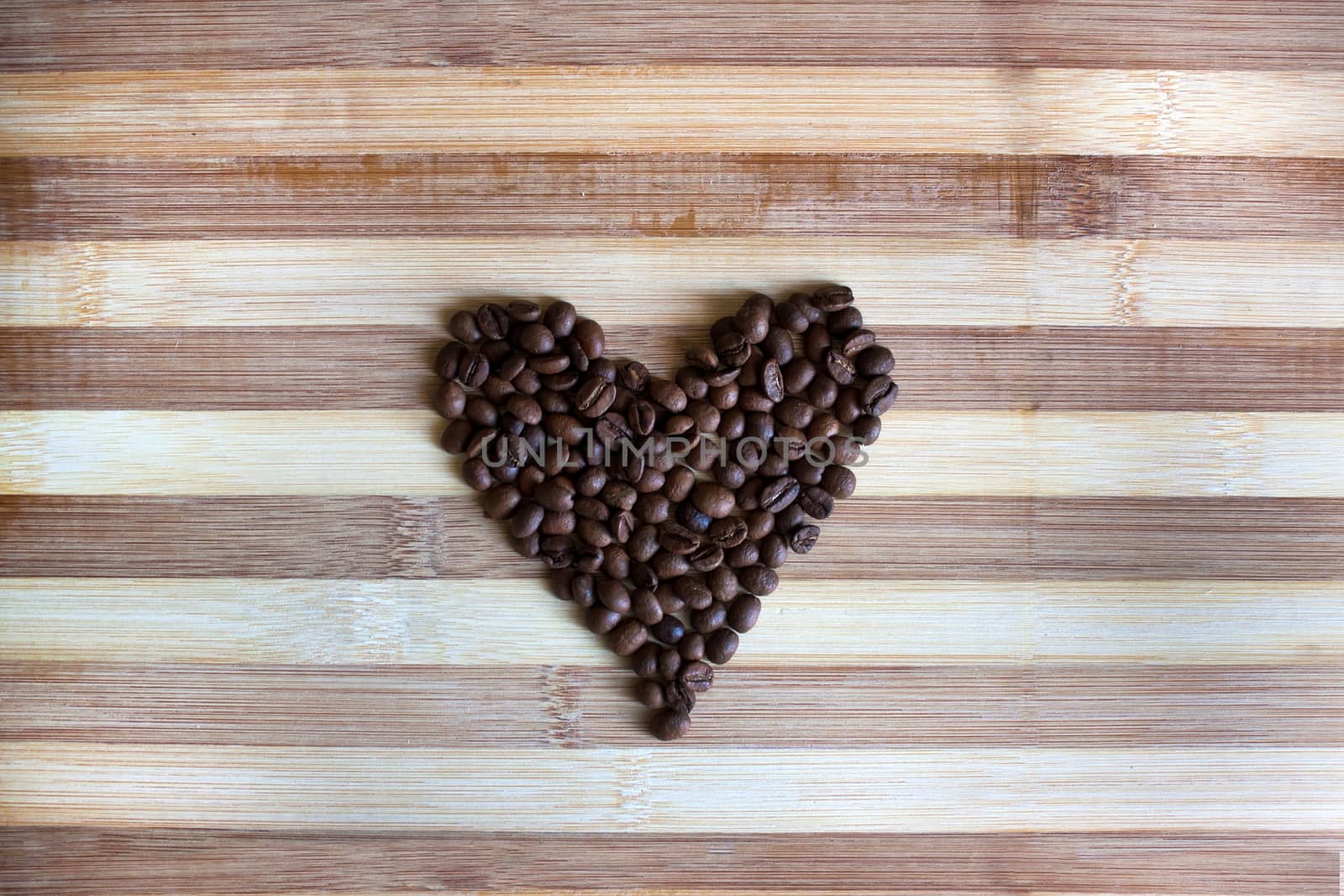 Heart of coffee beans on the wooden board