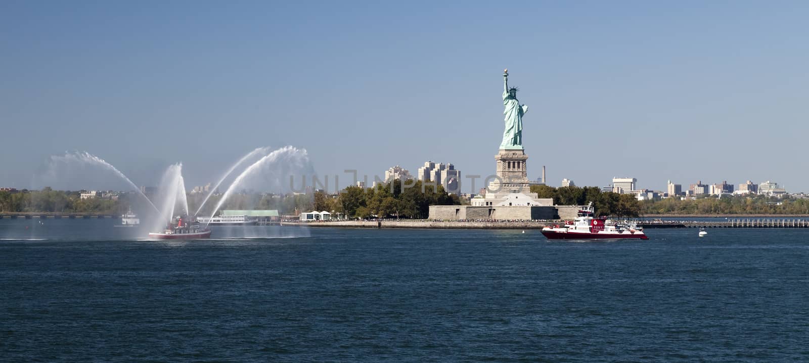 New York, USA, SEPT 27, 2014: The New York City Fire Department Boat practices maneuvers  in the Hudson River off New York City and Statue of Liberty