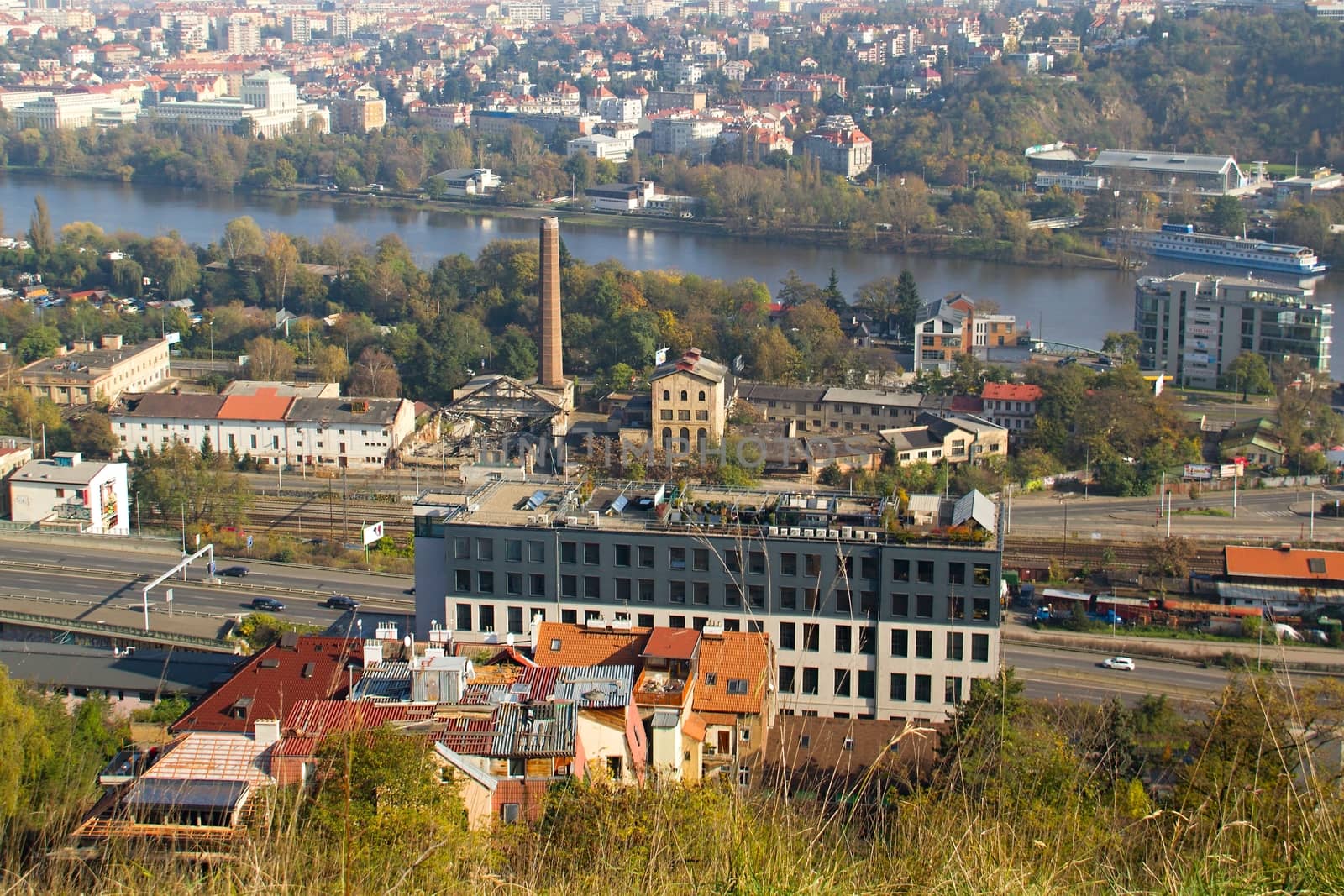 Photo shows a general city view with houses, trees and river.