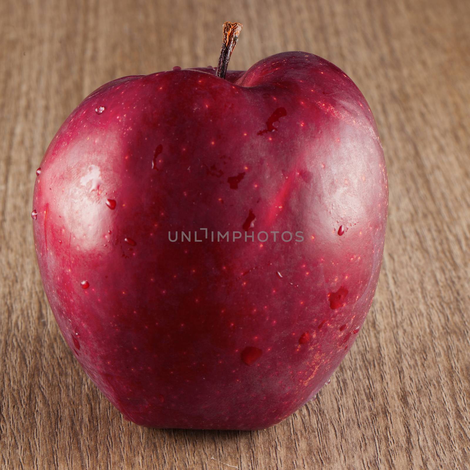 A red apple over a wooden background