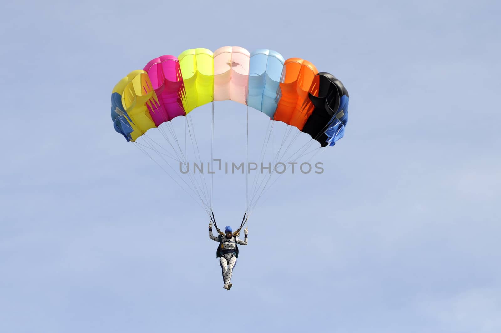 the parachutist goes down on a multi-colored parachute