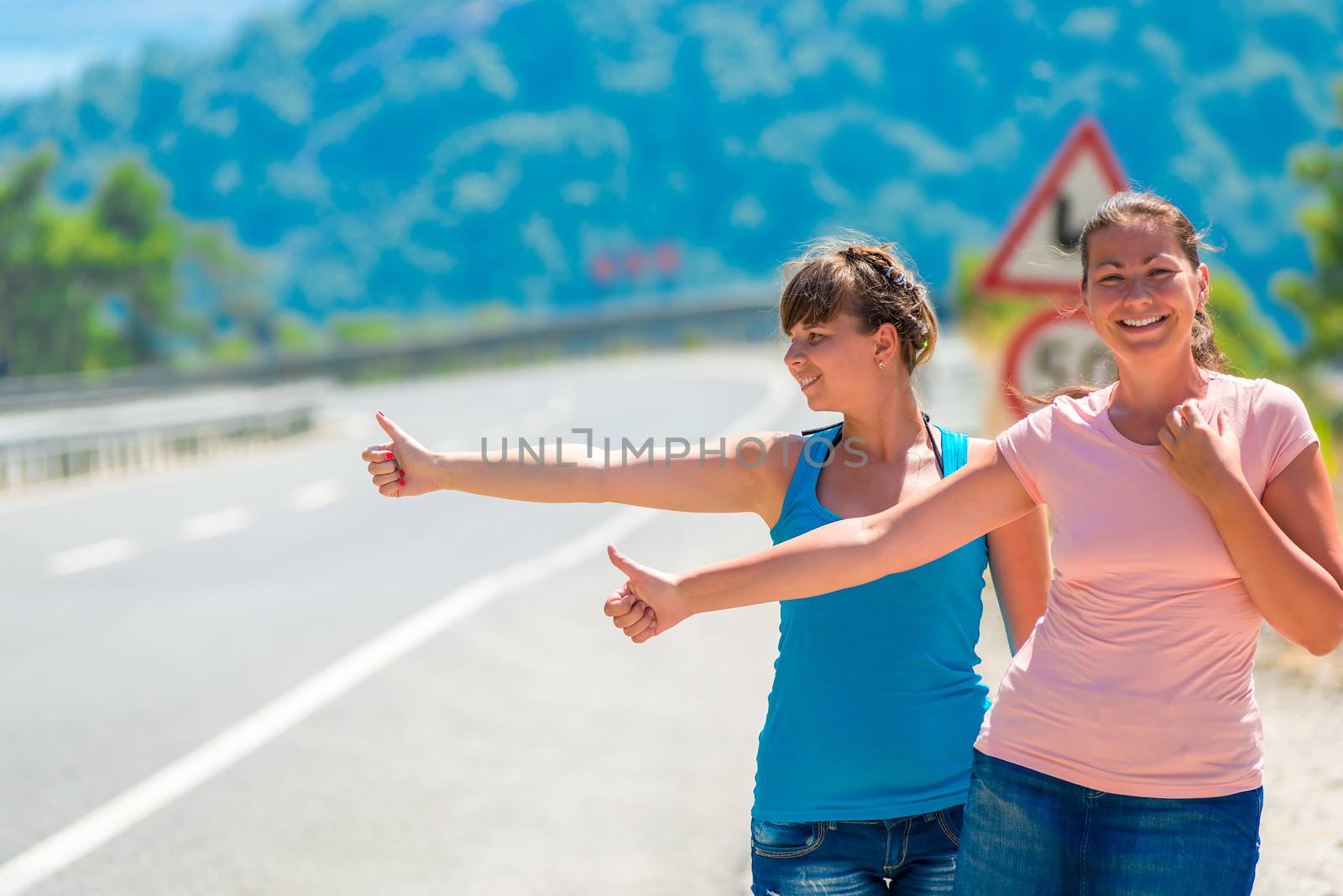 funny young girl hitchhiking in the mountains