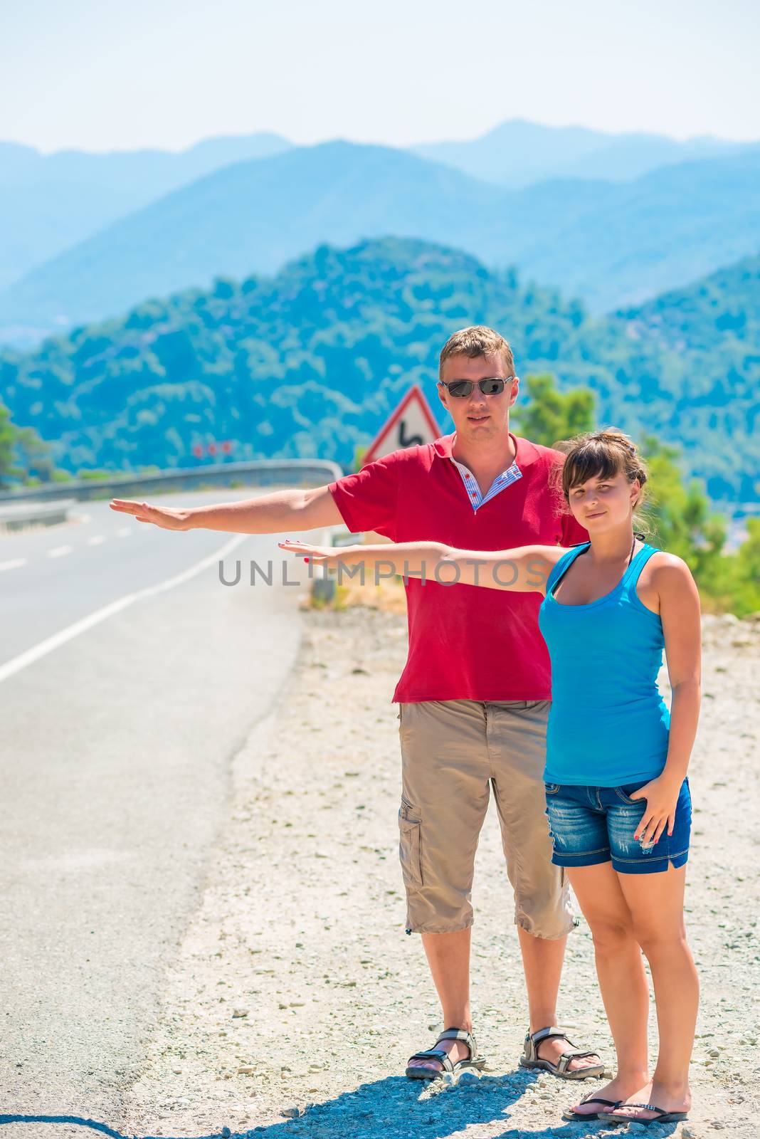 married young couple hitchhiking summer day by kosmsos111