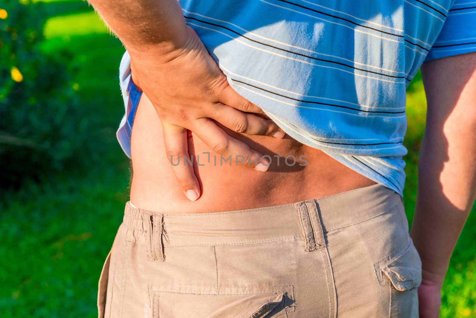 man holding his hand sore lower back