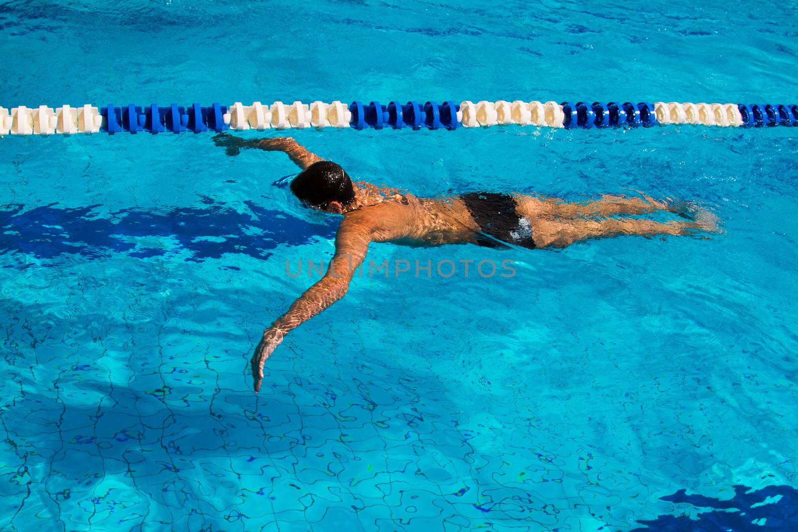 Professional swimmer dives under water in the pool - Stock Image