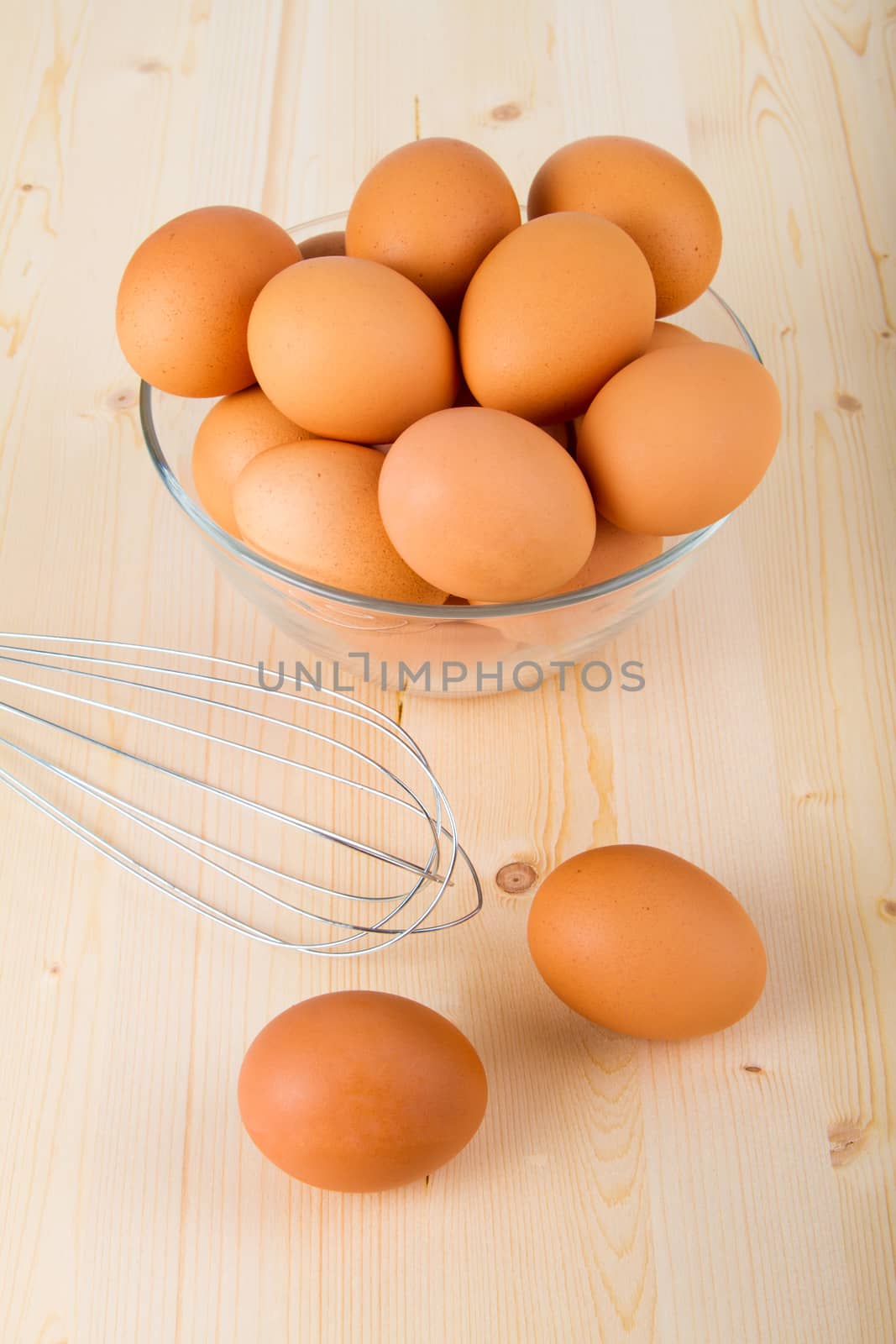Fresh brown eggs in a bowl on wooden table