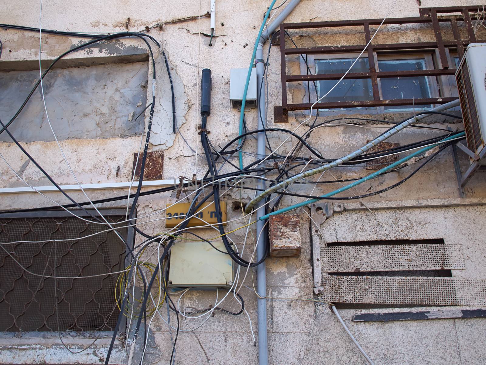 Tangled electric cable mess on a wall of building