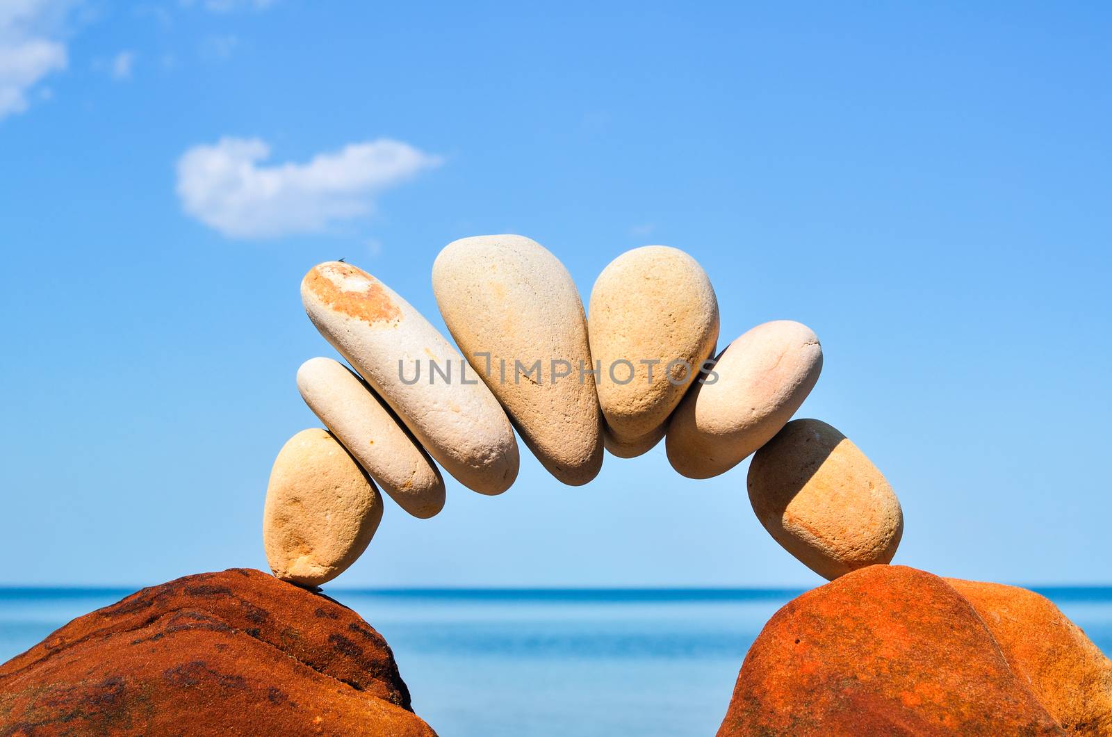 Curve of pebbles between of the stones on the coast