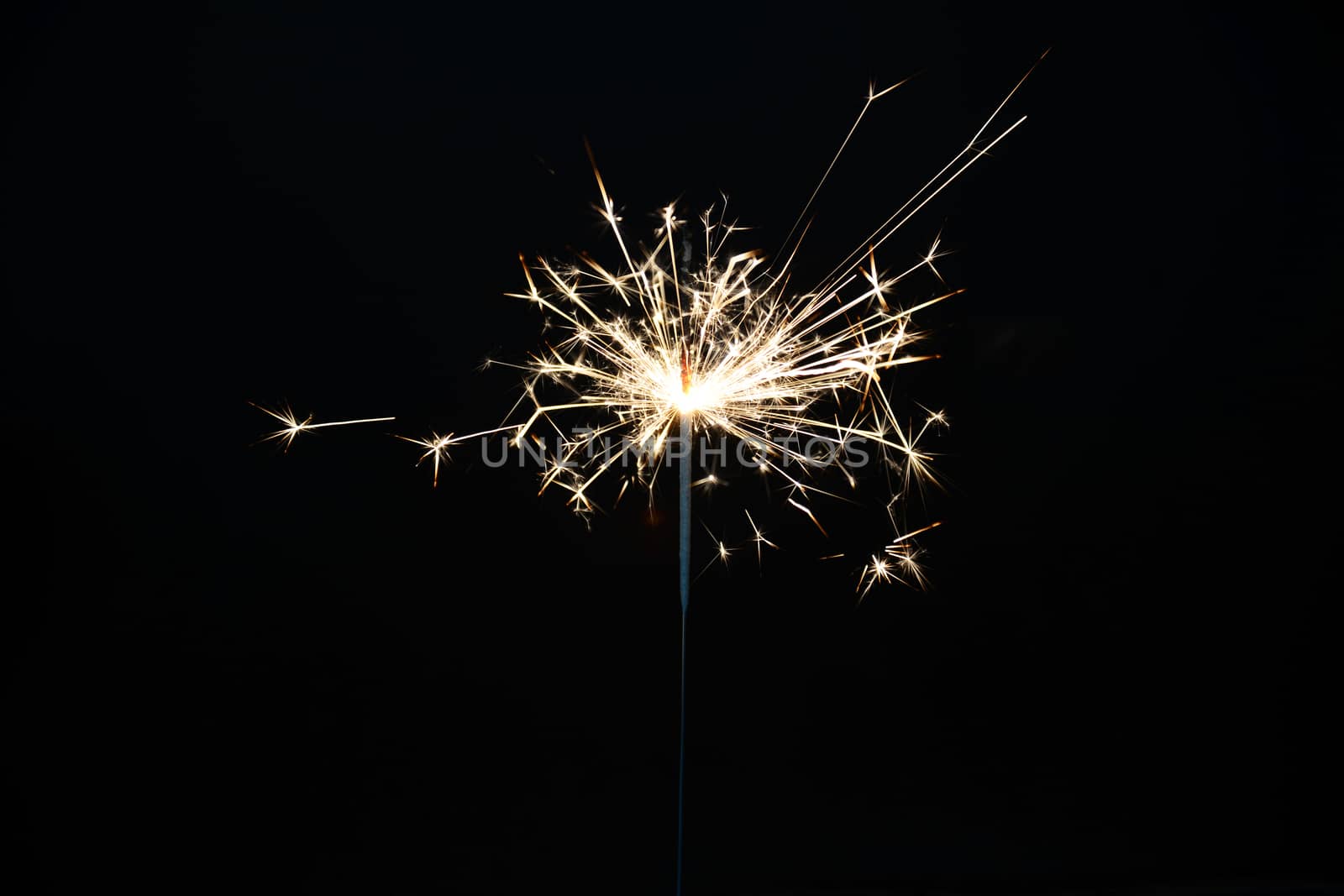 Photo of a burning christmas sparkler isolated on black background. Objects photography.