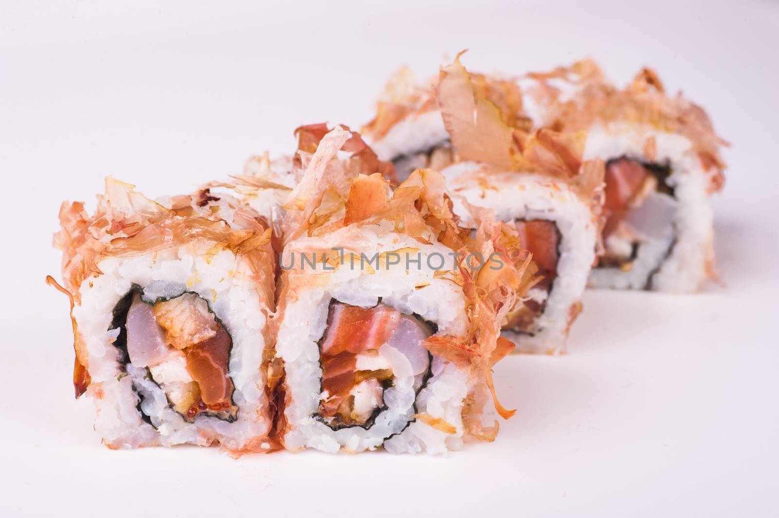 salmon sushi roll in tuna flakes isolated on white background 