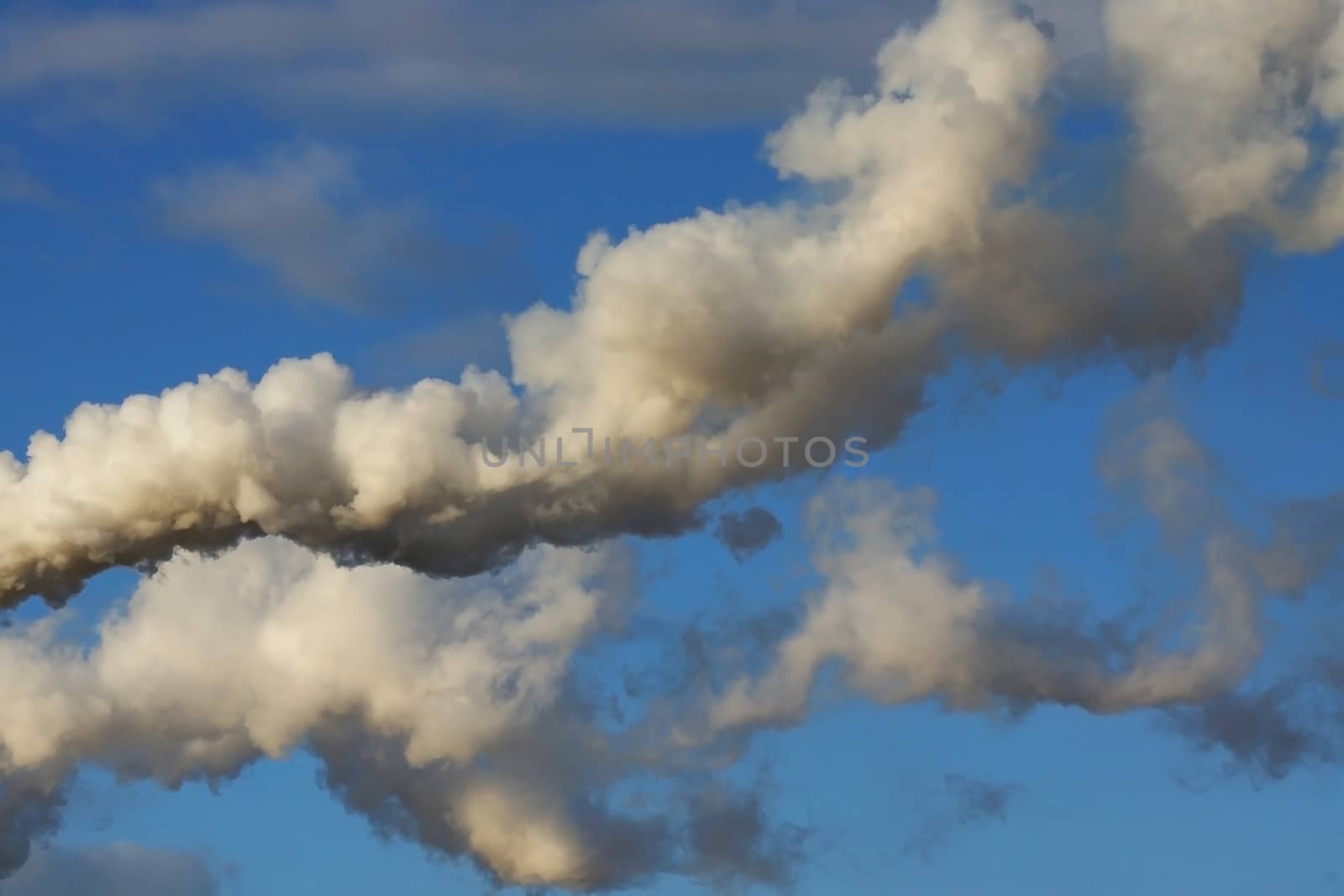 Photo of industrial smoke on a blue sky. Illustration of industrial pollution, environmental problems.
Taken in Riga, Latvia.