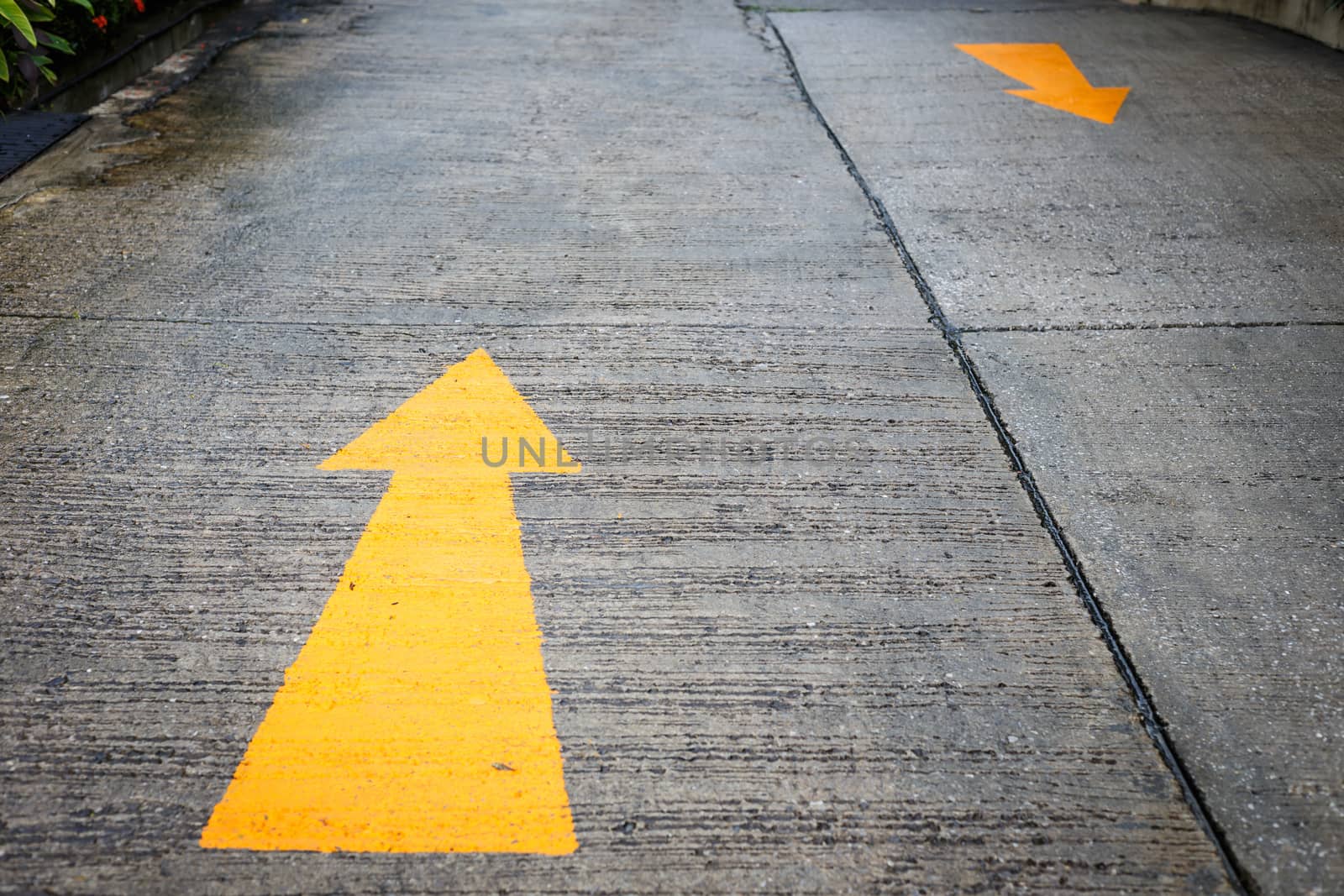 A yellow arrow symbol on a road surface