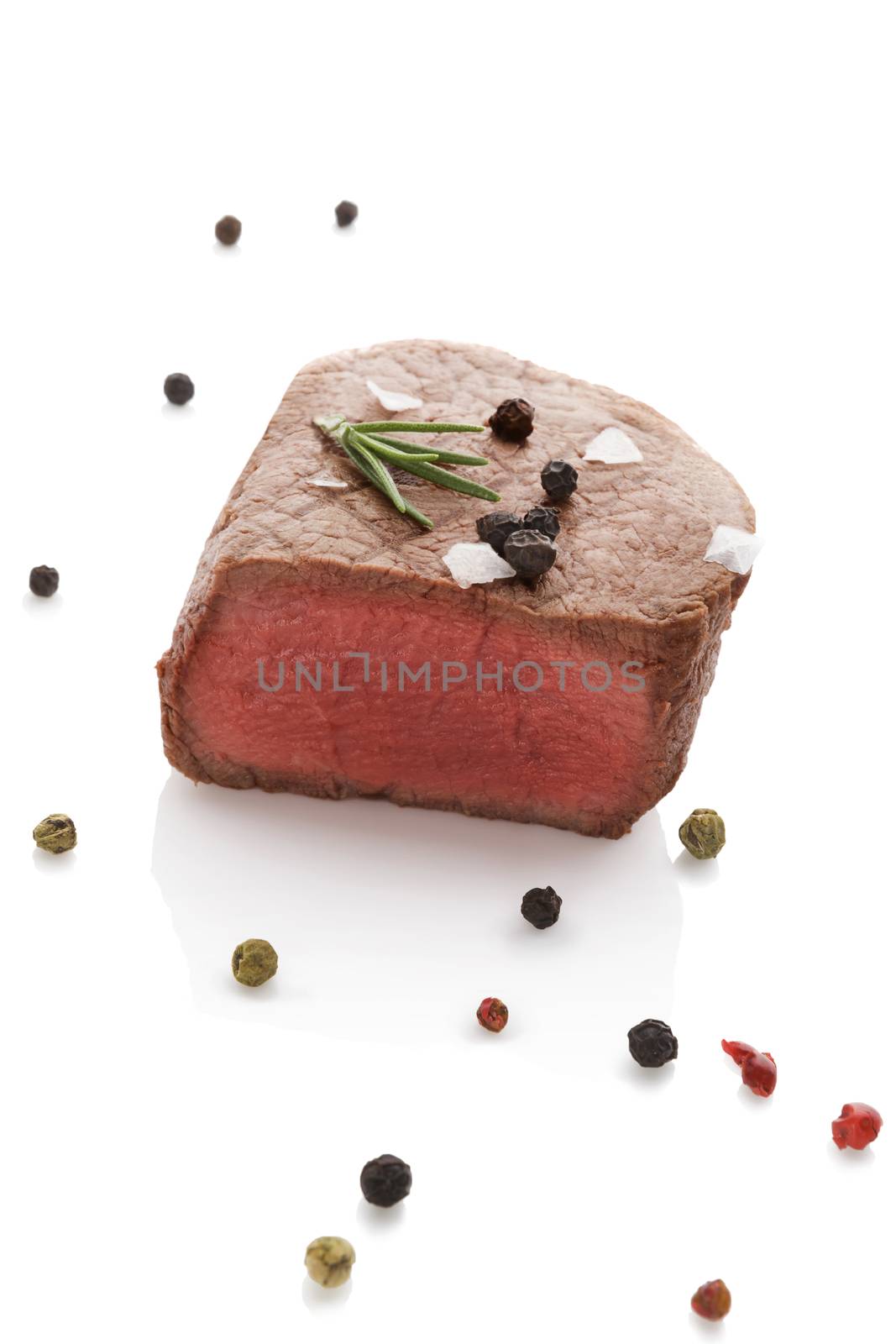 Beefsteak with rosemary and colorful peppercorn isolated on white background. Culinary red meat eating.