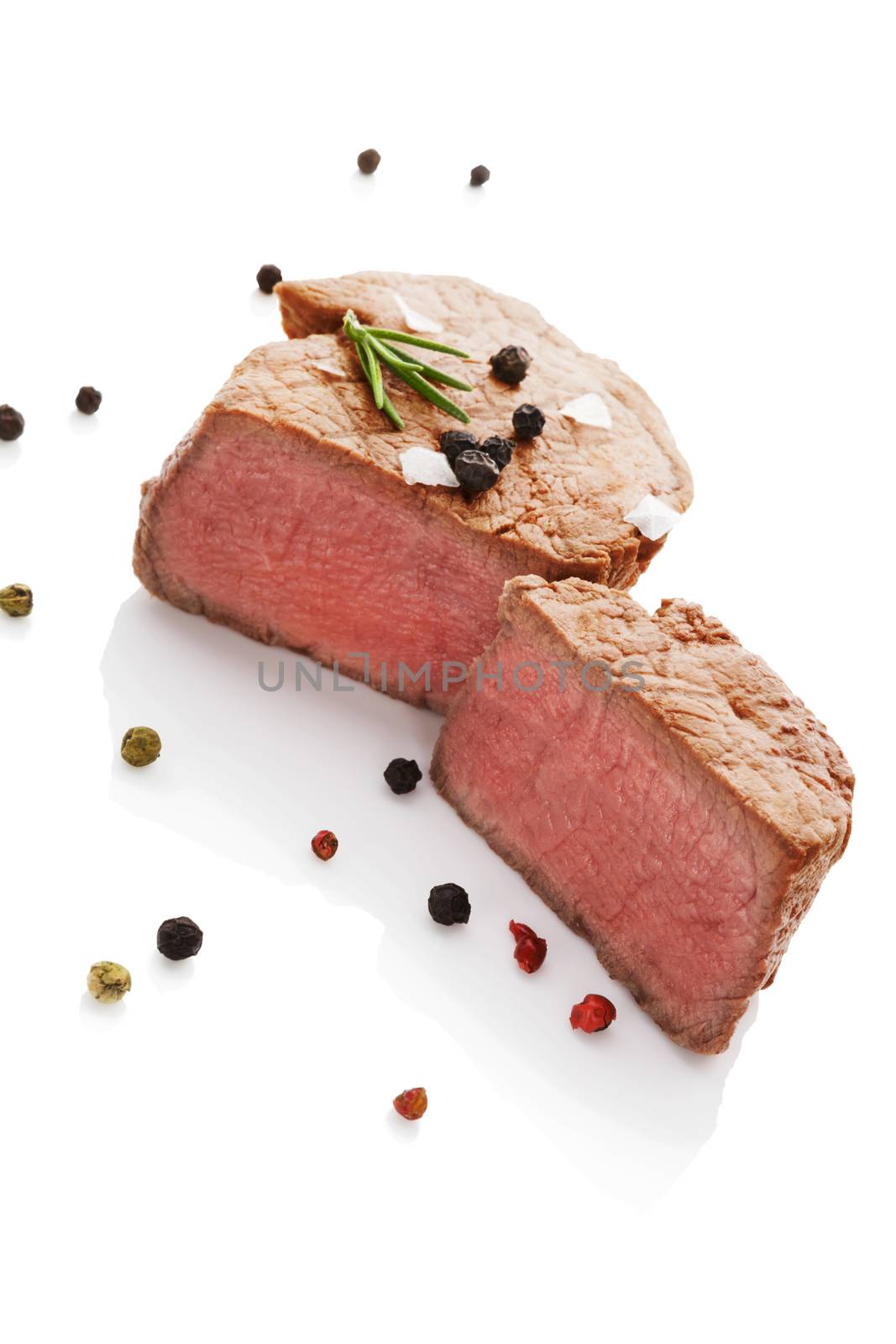 Beefsteak with rosemary and colorful peppercorn isolated on white background. Culinary red meat eating.