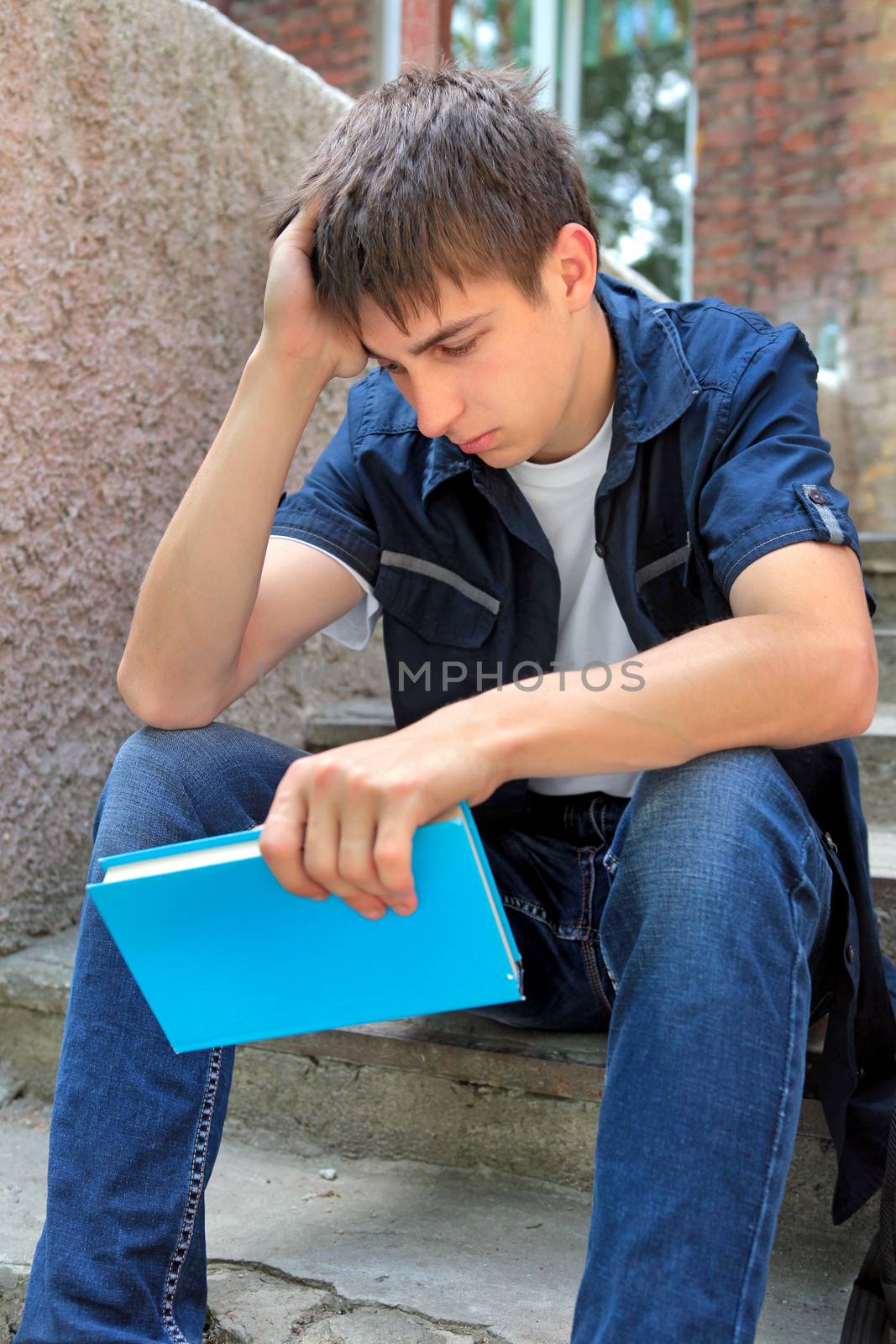 Sad Student with the Book on the landing steps