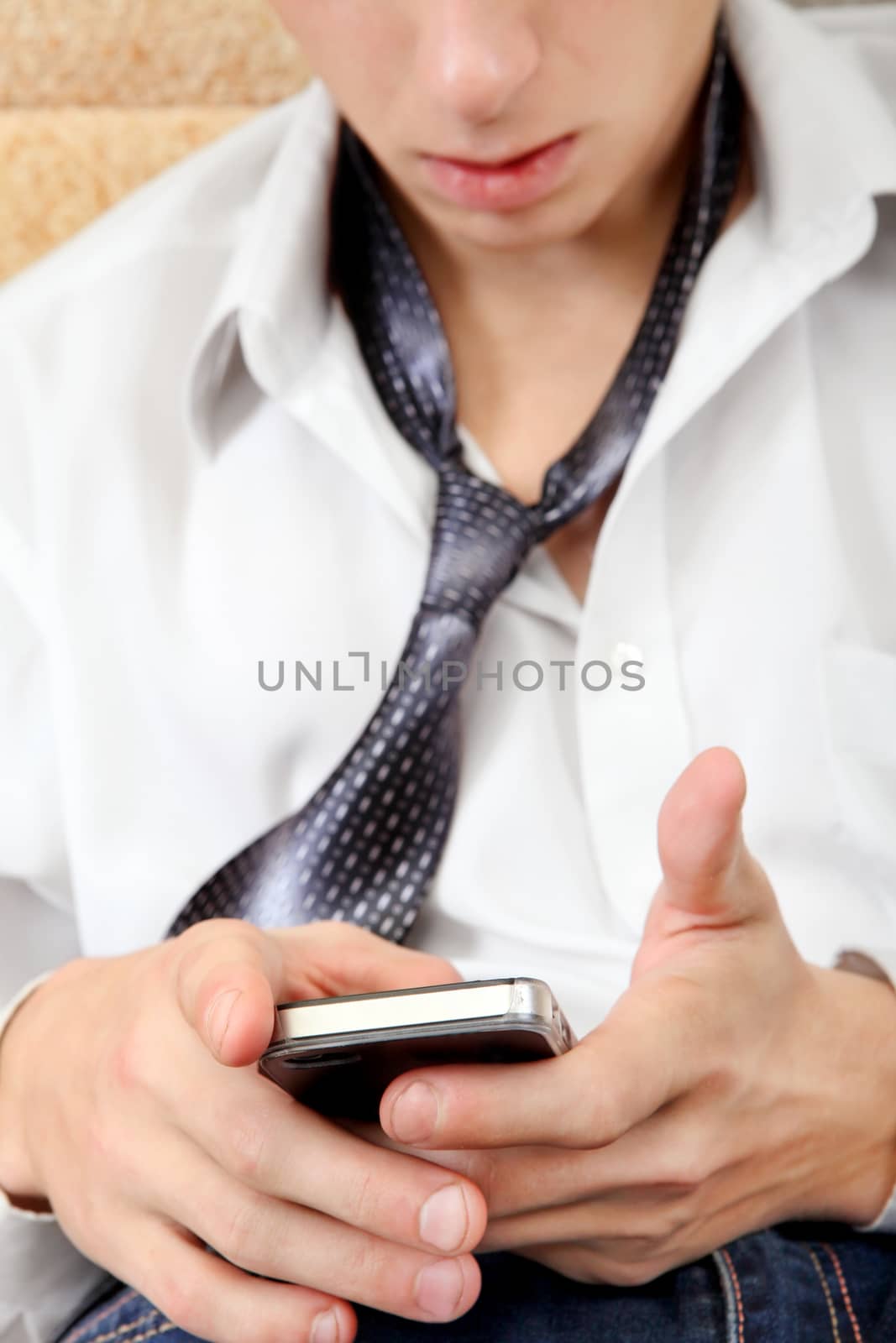 Focus on the Phone. Teenager with Cellphone on the Sofa