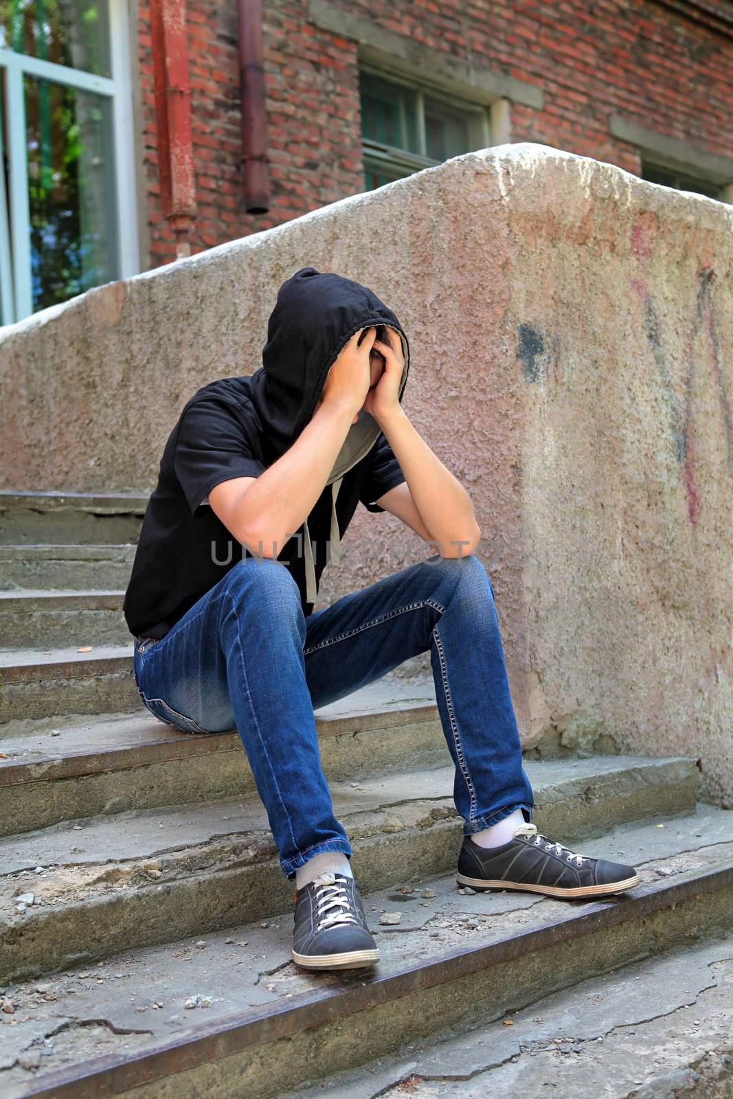 Sad Teenager on the landing steps of the Old House