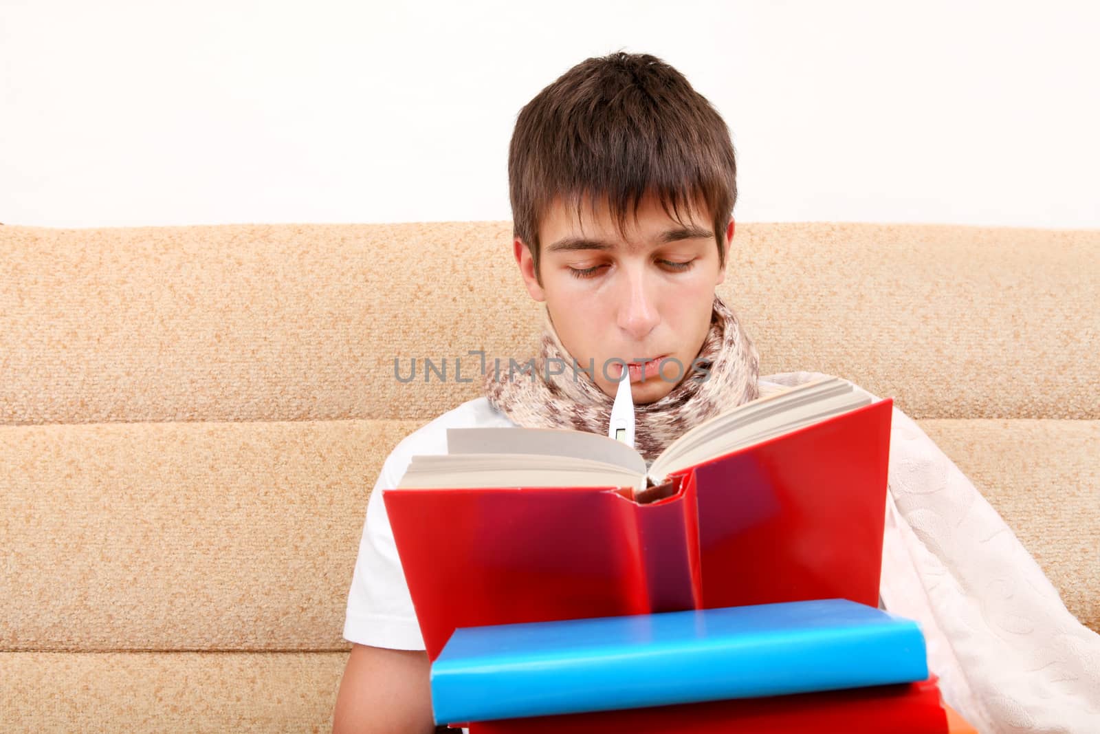 Sick Teenager with Thermometer reads the Books at the Home