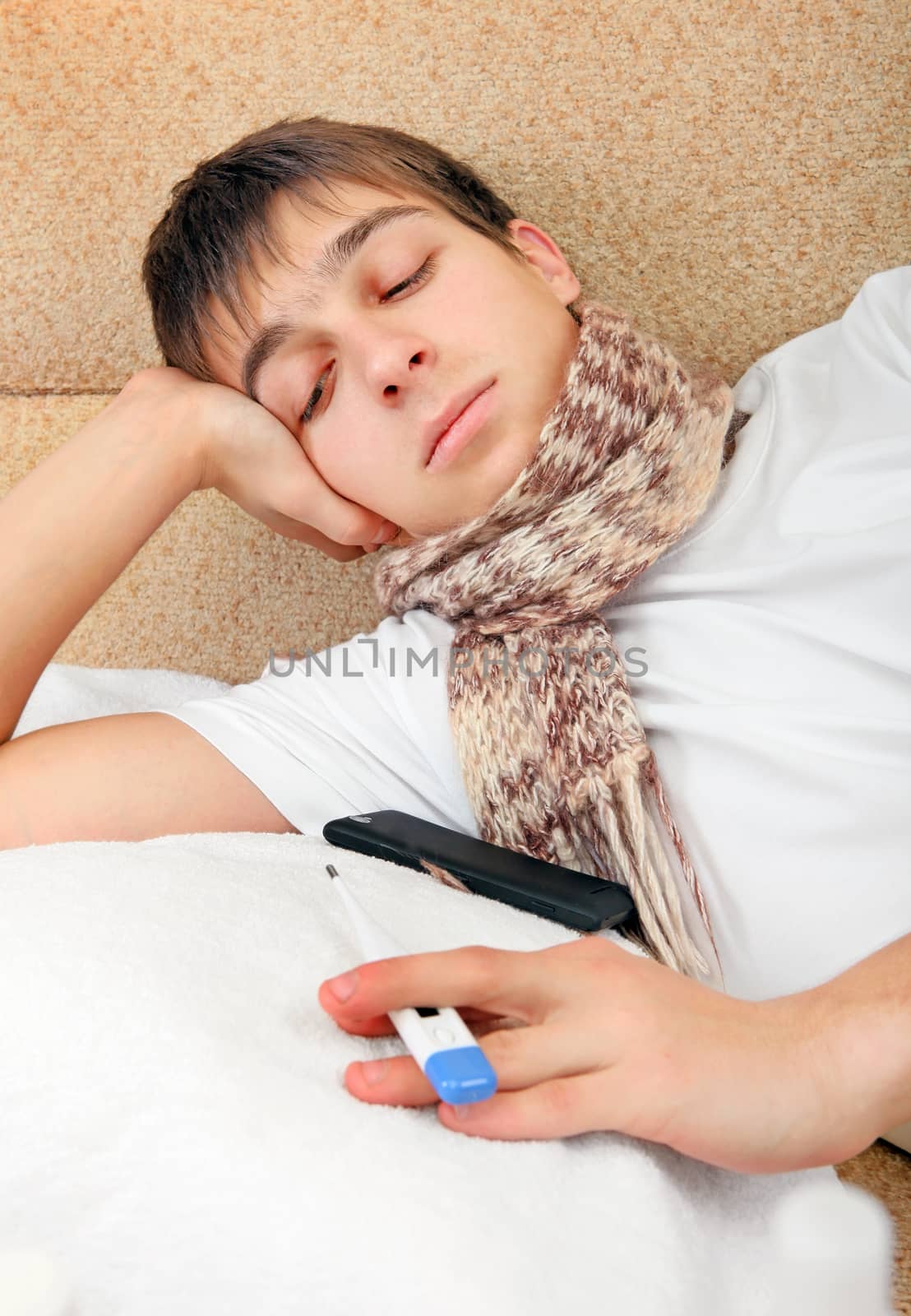 Sick Teenager with Thermometer on the Sofa at the Home