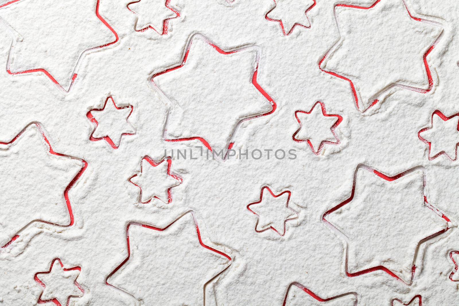 Christmas stars on flour background. White flour looks like snow. Top view