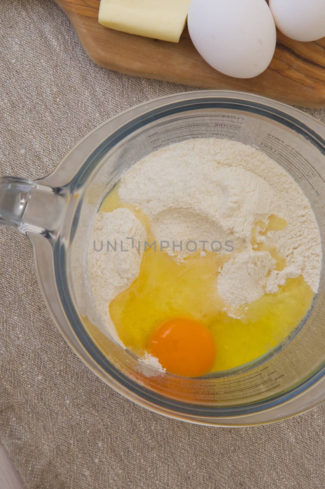 Ingredients for preparing biscuits in the glass measuring cup by tolikoff_photography