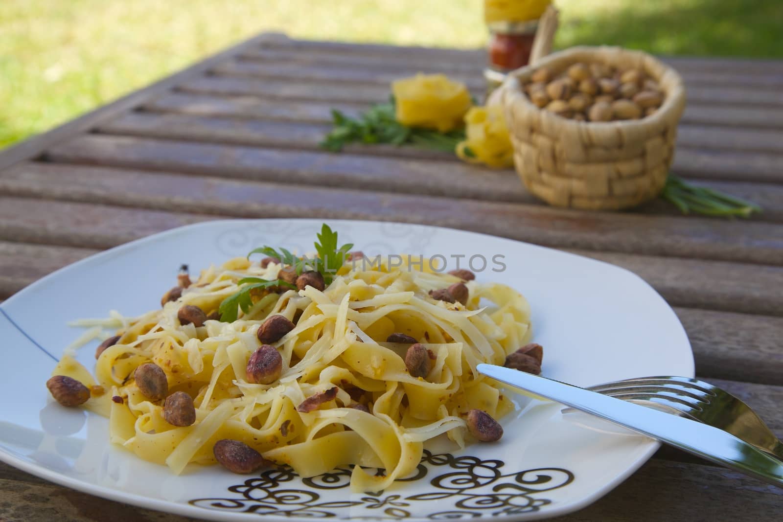 A plate of Italian pasta with pistachio pesto and parmesan cheese. Ingredients in the background