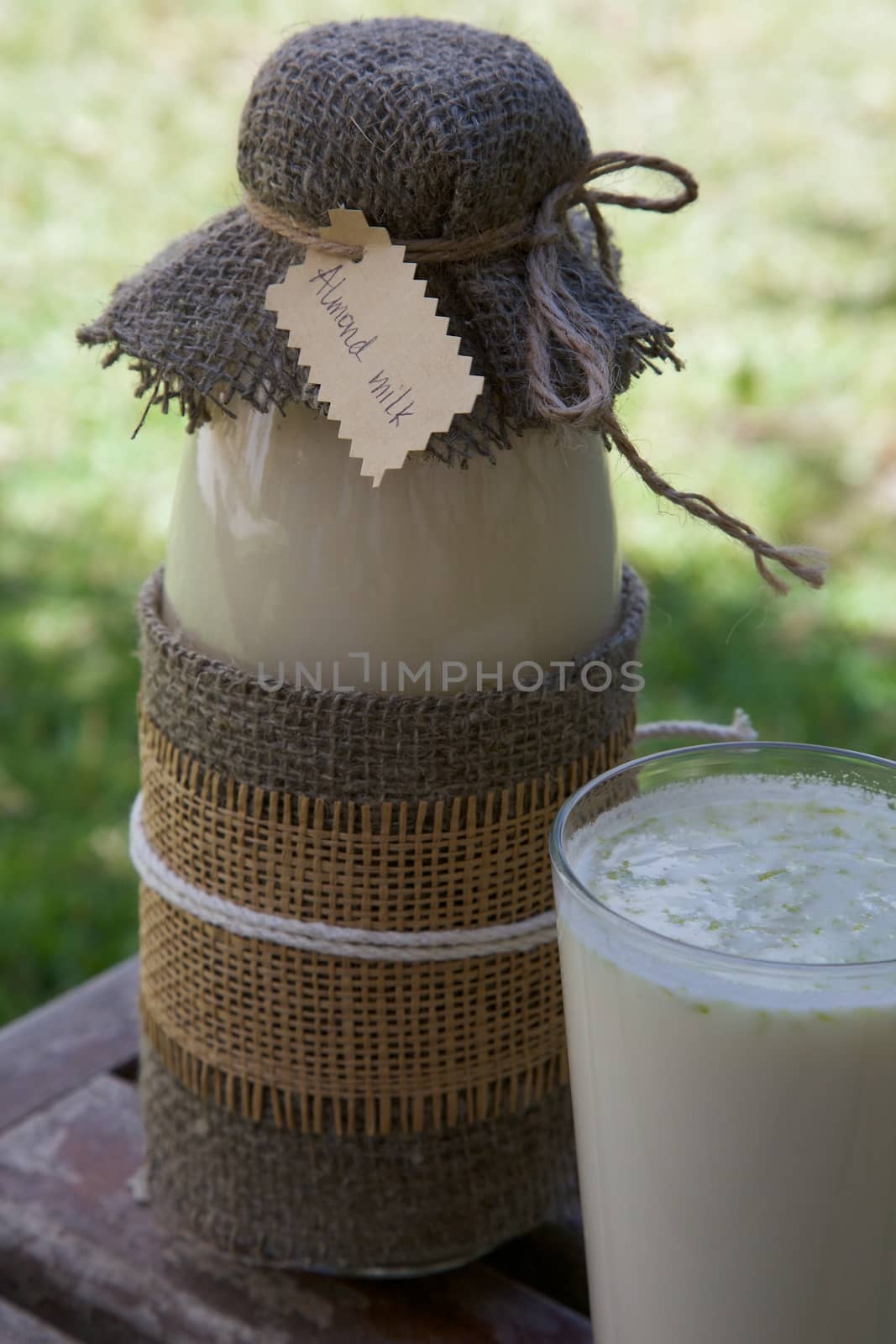 Homemade almond milk in the bottle by tolikoff_photography