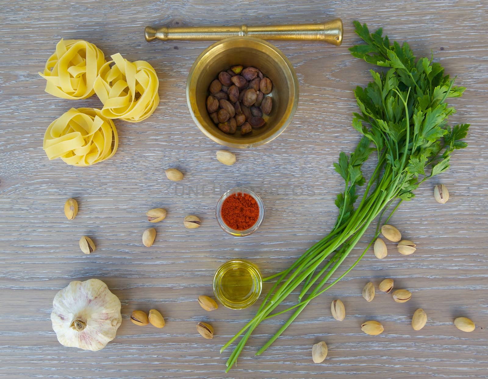 Ingredients for preparing pasta with pistachio pesto on a wooden surface. Top view. Background