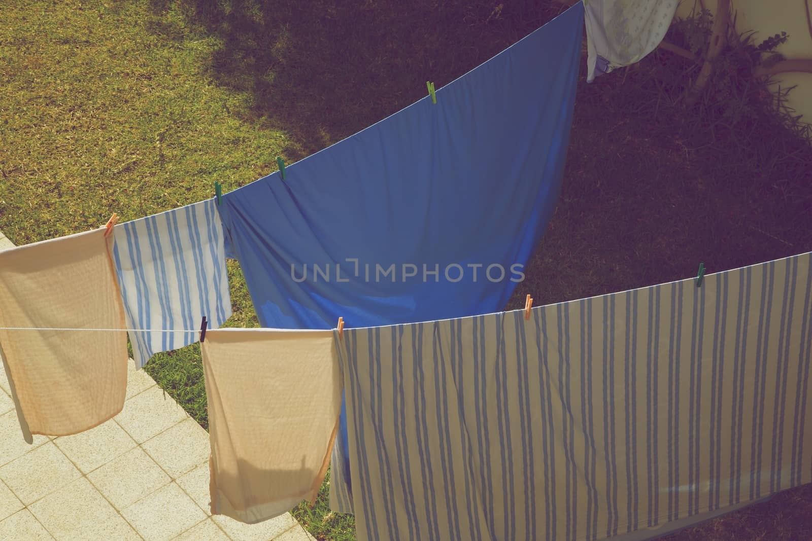 Hanging bedclothes in the garden by tolikoff_photography