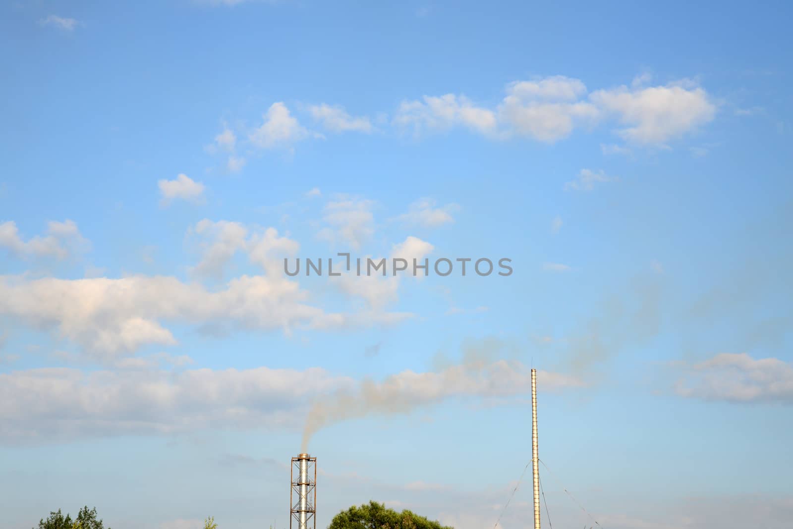 Photo of industrial smoke from a chimney on a blue sky. Illustration of industrial pollution, environmental problems.
Taken in Riga, Latvia.
