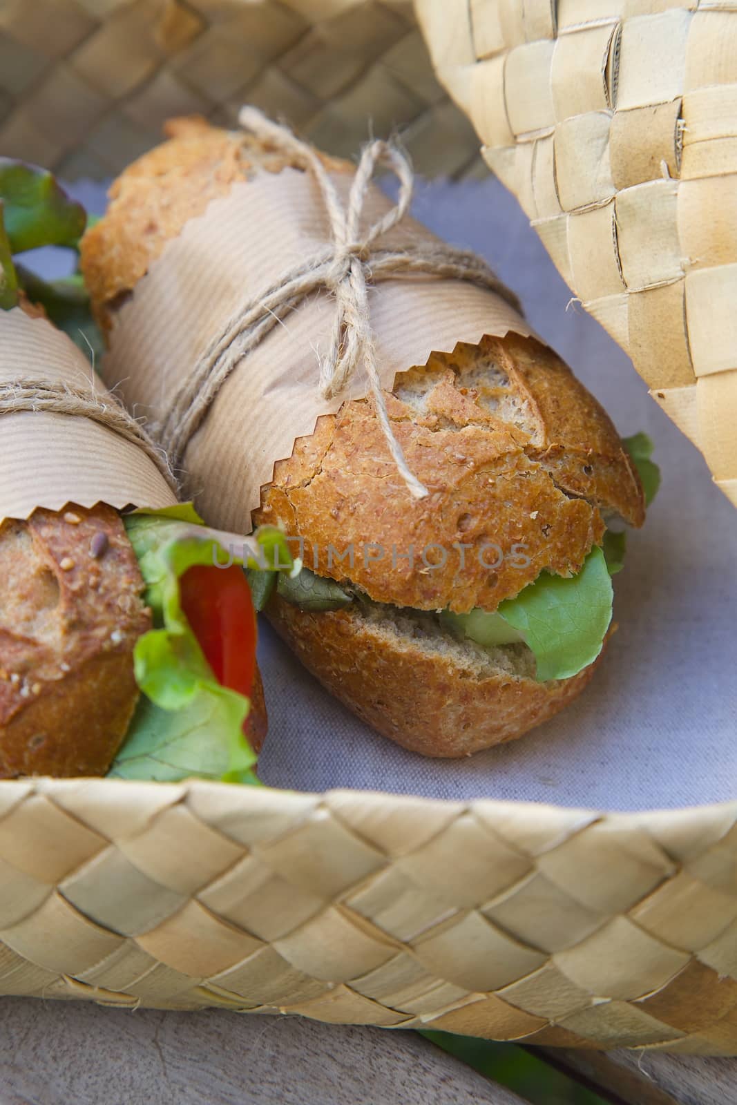 An open-air  express lunch for a vegetarian- whole grain rolls with fresh vegetables. Rolls are hidden in the woven birch basket