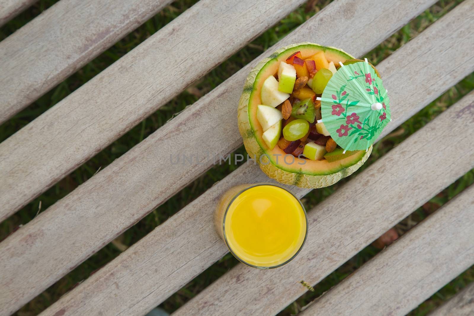 Vitamin dessert - fruit salad in the melon skin and a glass of fresh orange juice by tolikoff_photography