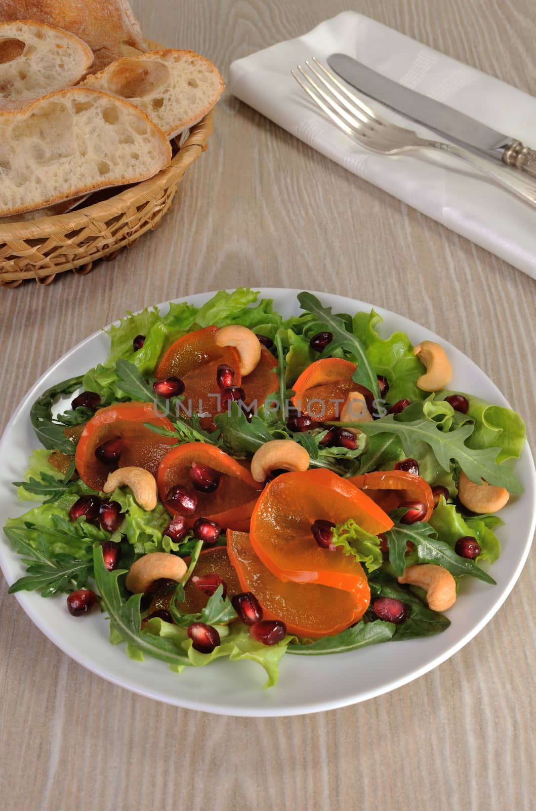 salad of spinach, arugula, lettuce, persimmon, pomegranate and cashews