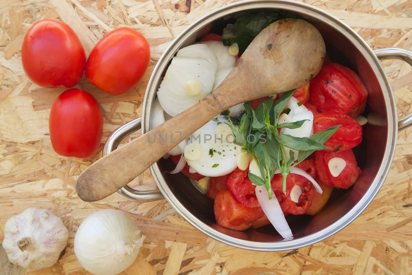 Prepared food ingredients for cooking Italian tomato sauce - salsa. Ingredients are placed in the pot by tolikoff_photography