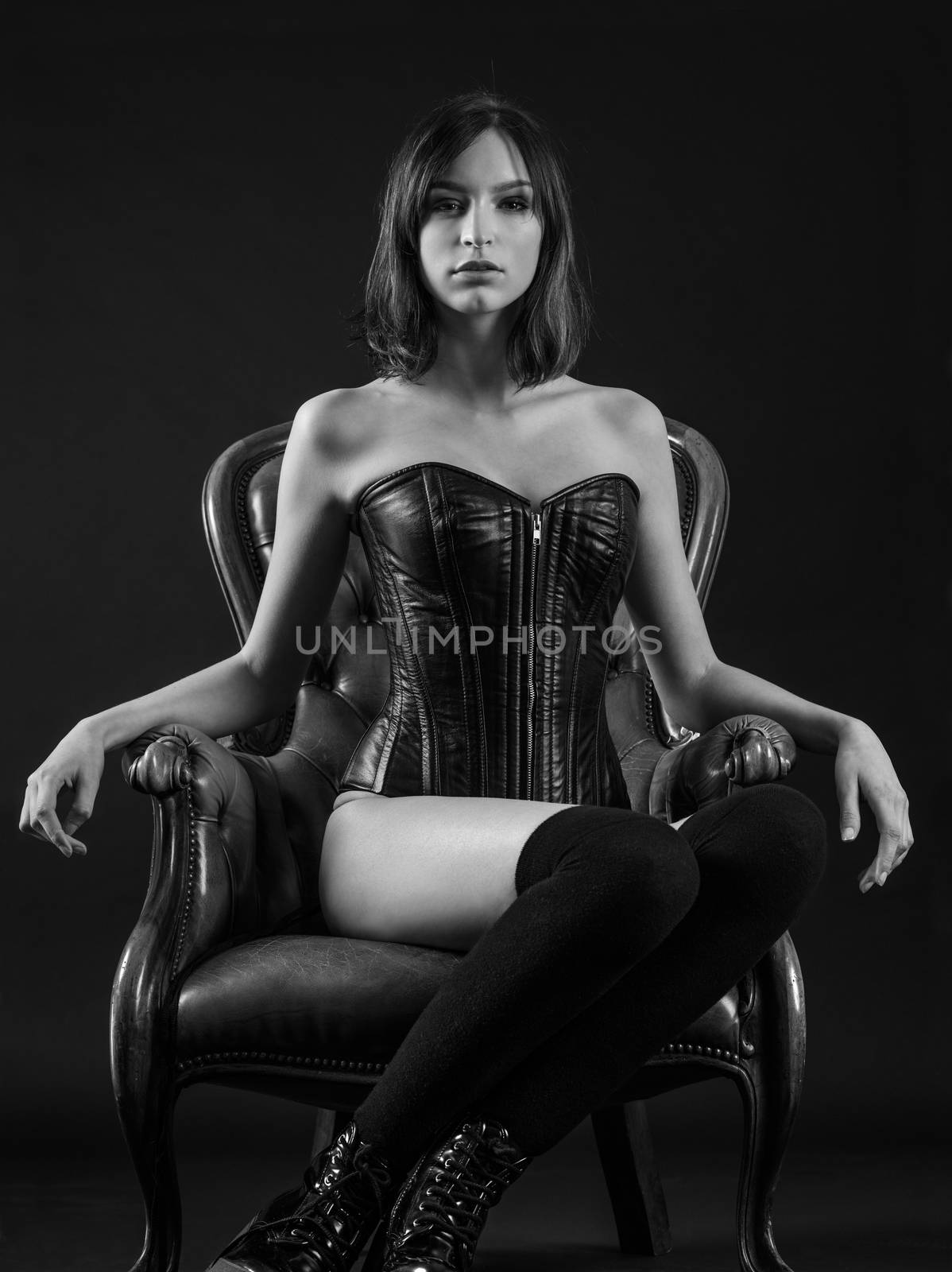 Beautiful woman sitting wearing a corset by sumners