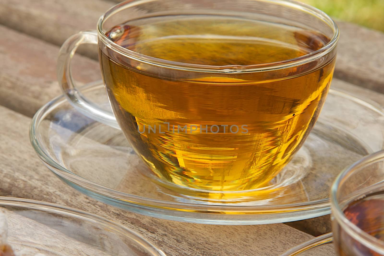 A glass cup of tea on an old wooden surface
