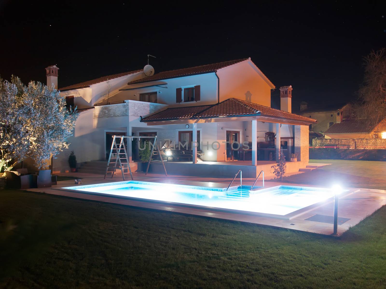 swimming pool and house at night, under lights