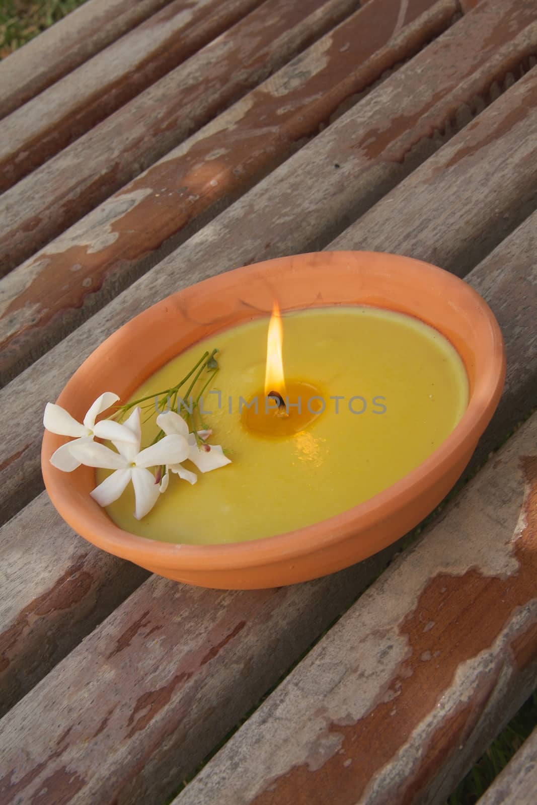 Garden jasmine candle on the wooden surface
