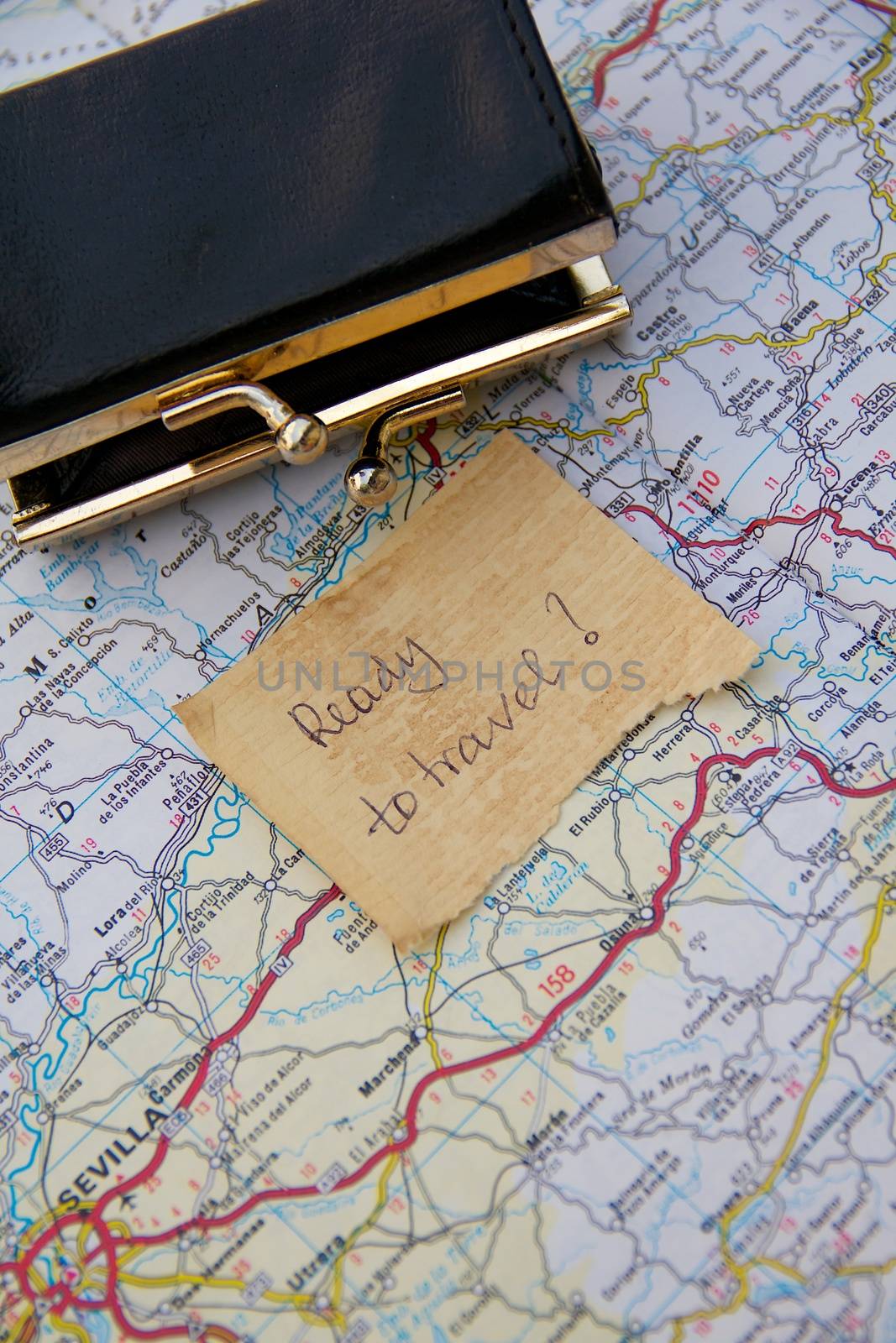 Message left on the road map close to the small opened and empty wallet:"Ready to travel?" 